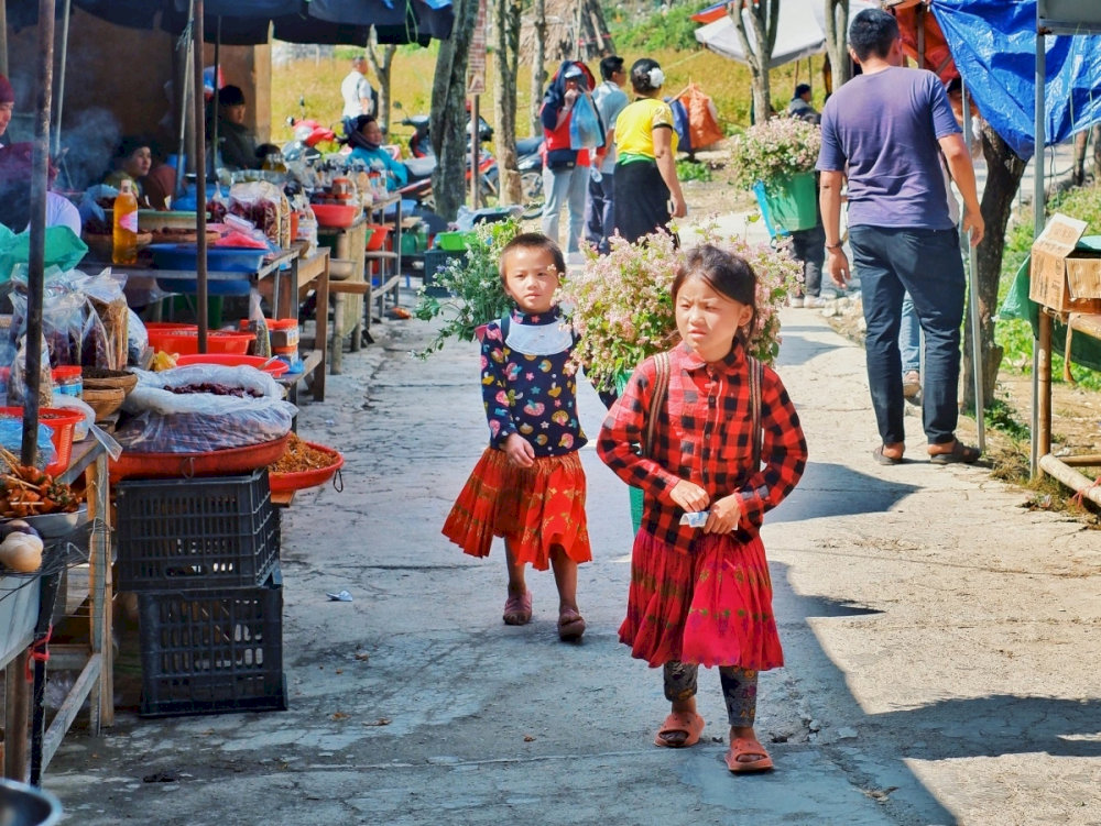 Children follow their mothers to the market to sell goods